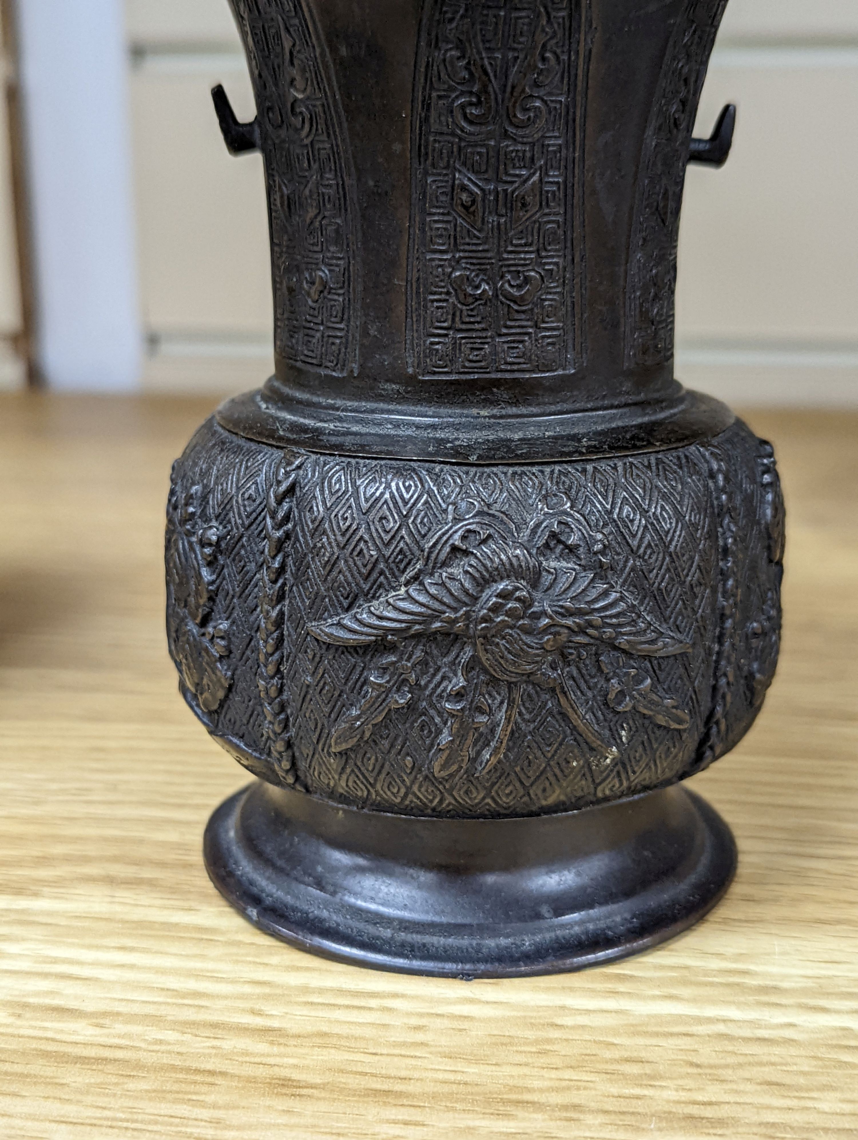 A pair of Japanese Meiji period bronze ‘dragon’ bottle vases and another, 21cm